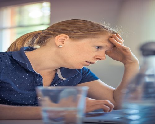 man sitting for a long time at an office desk looking tired